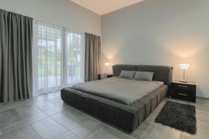 a bedroom with a large bed and a large window at 9 April Village Sea & Spa Varna in Varna City +13 photos