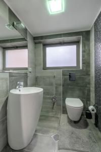 a bathroom with a white tub and a toilet at 9 April Village Sea & Spa Varna in Varna City