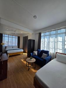 una camera con due letti e un divano blu di The Olive Inn a Shillong