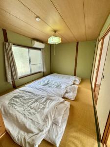 Ένα ή περισσότερα κρεβάτια σε δωμάτιο στο 関西空港近く- JR日根野駅前 The Palm guest house