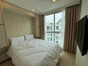 een slaapkamer met een wit bed en een groot raam bij Olympus City Garden Condo Pattaya High Floor 8F in Ban Nong Chaeng +45 foto's