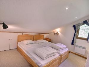 ein Schlafzimmer mit einem Holzbett mit weißer Bettwäsche in der Unterkunft Spacieux appartement 4 pièces, 8 pers., proche pistes à Vallandry - FR-1-411-849 in Landry