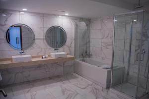 マプトにあるWL Hotel Maputo Executiveのバスルーム(シンク2台、バスタブ、鏡付) +39枚の写真