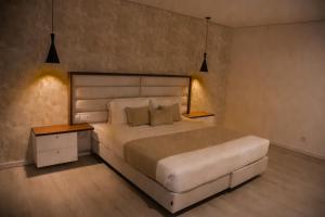 マプトにあるWL Hotel Maputo Executiveのベッドルーム(大きな白いベッド1台、ナイトスタンド付)