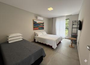 En eller flere senge i et værelse på Villa Parati Bombinhas