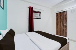 um quarto com uma cama branca e preta em Hotel O Anmol Residency em Nova Deli