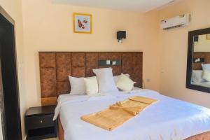 オウェリにあるProximus Hotel and Suitesの木製のヘッドボードが付いた大きなベッドのある寝室