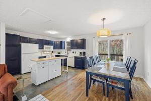 a kitchen with blue cabinets and a table with chairs at Red Fox Den - Luxurious home 10 guests 5 beds in Massanutten in McGaheysville