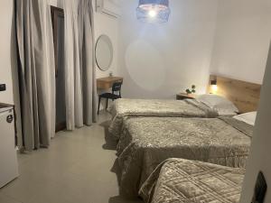 オウランオウポリにあるSENSIMAR Rooms To Letのベッドが2つと鏡があるホテルの部屋