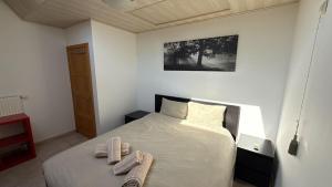 a bedroom with a bed with two towels on it at Baobab - Villa - Jardin in Saint-Ghislain