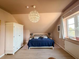 Grödersbyにあるvilla kunterBUNTのベッドルーム(青いベッド1台、シャンデリア付)