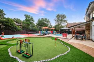 een achtertuin met een speeltuin met speelapparatuur bij Pool Games Pickleball & Putt Putt Fun in San Antonio