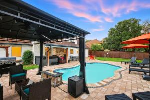 een patio met een zwembad en een parasol bij Pool Games Pickleball & Putt Putt Fun in San Antonio