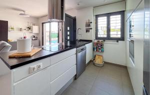 eine Küche mit weißen Schränken und einer schwarzen Arbeitsplatte in der Unterkunft Stunning Home In Rojales in Ciudad Quesada