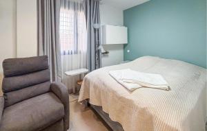 ein Schlafzimmer mit einem Bett und einem Stuhl und einem Fenster in der Unterkunft Stunning Home In Rojales in Ciudad Quesada