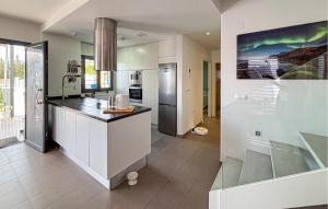 eine Küche mit weißen Schränken und einer Arbeitsplatte in der Unterkunft Stunning Home In Rojales in Ciudad Quesada