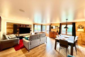 a living room with a couch and a table at Renovated village house with terrace and quiet in Combloux