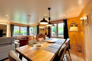 a dining room with a wooden table and chairs at Renovated village house with terrace and quiet in Combloux