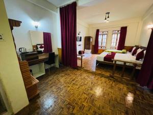 a room with a bedroom with a bed and a desk at Changu Che Retreat ! Pelling in Pelling
