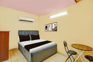 a bedroom with a bed and a table and chairs at Hotel O Moontara in Faridabad