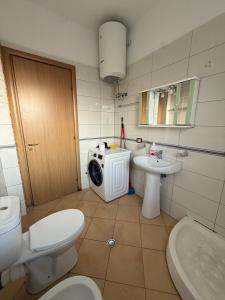a bathroom with a toilet a sink and a washing machine at Grand Bazaar BALCONY in Tirana