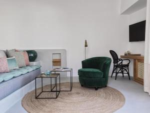 a living room with a couch and a chair and a table at Notia Suite, Jacuzzi, Imerovigli in Imerovigli