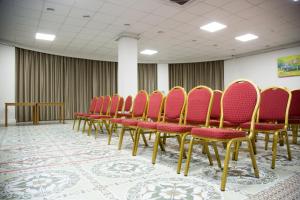a row of red chairs in a room at Baitau Hotel Aktobe in Aktobe