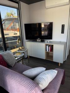 een woonkamer met een bank en een flatscreen-tv bij Lukrecja HouseBoat in Wrocław