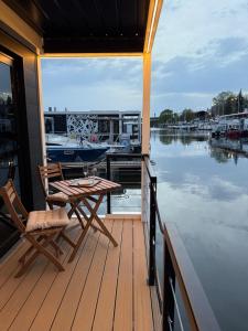 een houten terras met een tafel en stoelen op een boot bij Lukrecja HouseBoat in Wrocław