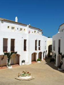 a large white building with a fountain in the courtyard at Sol Falcó Menorca in Son Xoriguer +89 photos