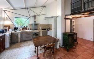a kitchen with a wooden table and a stove at Gorgeous Home In Lussan in Fons-sur-Lussan