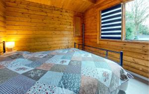 une chambre avec un lit dans une cabane en rondins dans l'établissement 2 Bedroom Awesome Home In Chenac-Saint-Seurin-D', à Saint-Seurin-dʼUzet