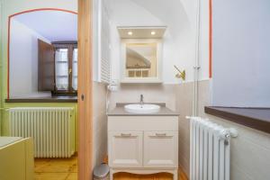 bagno con lavandino, specchio e radiatore di GuestHost - Antica Ferrovia Apartments Tarvisio a Tarvisio Altre 128 foto