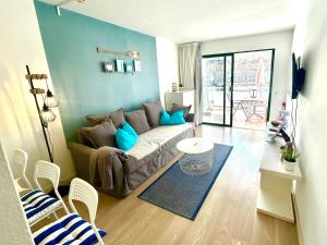 a living room with a couch and a table at OceanEye Apartment with heated pool in Mogán
