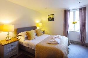 ein Schlafzimmer mit einem Bett und einer Lampe und einem Fenster in der Unterkunft Historic Fireman's Cottage - Cosy Home - Close To Town Centre in Canterbury