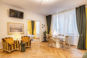 una sala de estar con una mesa y sillas en Casa Saba Trieste Luxury Apartment with terrace, en Trieste