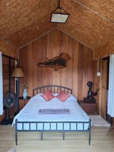a bedroom with a bed with a wooden wall at Here in chiang dao in Chiang Dao +9 photos