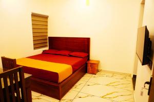 a bedroom with a bed with red and yellow at Sravan Villa in Vagamon