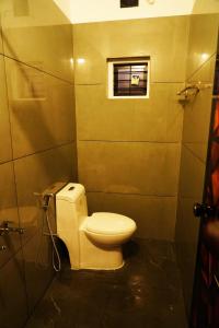 a bathroom with a toilet and a window at Sravan Villa in Vagamon