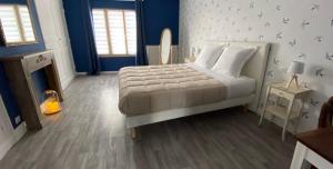 una camera da letto con un letto con pareti blu e un camino di Au Bois Dormant a Crécy-en-Ponthieu