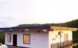 a small white house with a blue roof at Sravan Villa in Vagamon