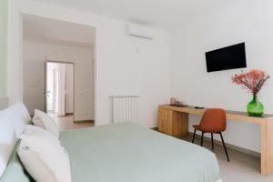 een slaapkamer met een bed en een bureau met een televisie bij Beddhra Mia - Lecce Selection in Lecce