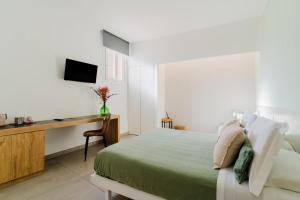een slaapkamer met een bed en een bureau met een televisie bij Beddhra Mia - Lecce Selection in Lecce