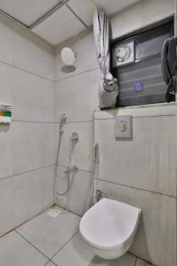 a bathroom with a toilet and a shower with at hotel monville in Vadodara