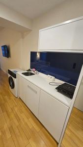 a white kitchen with a sink and a microwave at BLACK SEA ORBI APARTAMENT s in Angisa +6 photos