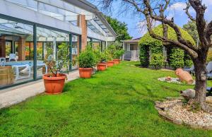 une rangée de plantes en pot devant une maison dans l'établissement Fontana Comfort Apartment, à Castelnuovo del Garda