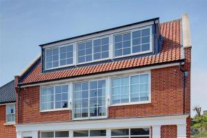 ein rotes Backsteingebäude mit vielen Fenstern in der Unterkunft Aldeburgh Dawn in Aldeburgh + 5 Fotos