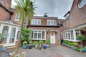 ein Backsteinhaus mit vielen Topfpflanzen in der Unterkunft Stable Mews Cottage in Royal Tunbridge Wells