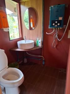 a bathroom with a toilet and a sink and a mirror at Here in chiang dao in Chiang Dao