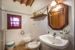 een witte badkamer met een wastafel en een toilet bij Casale Il Chicchero in Castel San Gimignano +5 foto's